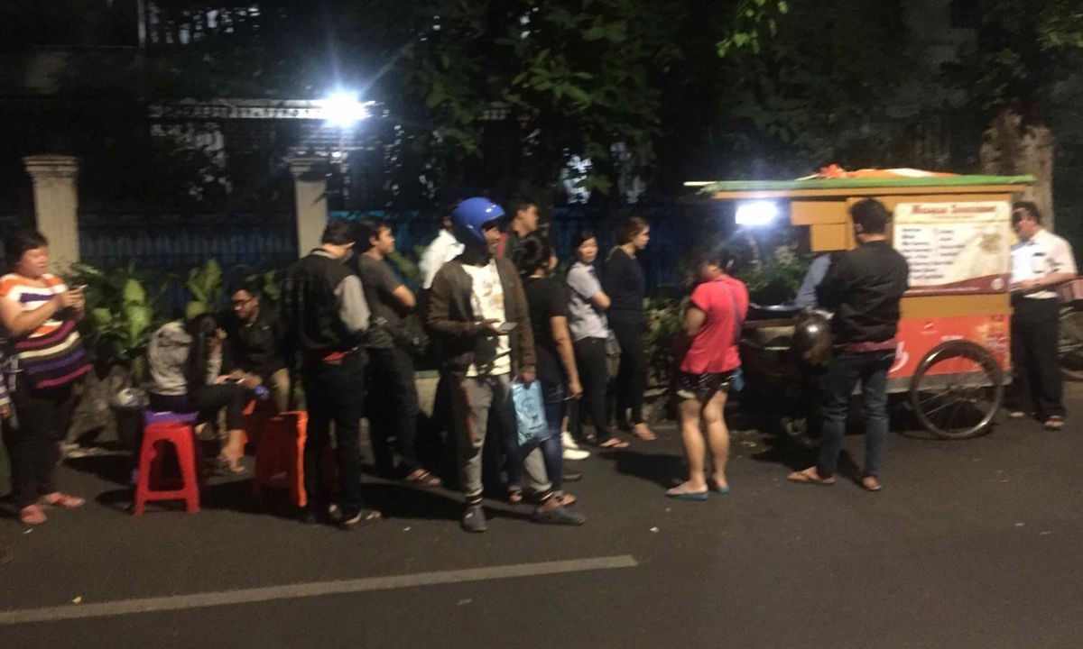 Usaha nasi goreng pinggir jalan dengan pelanggan yang menikmati makanan di lokasi